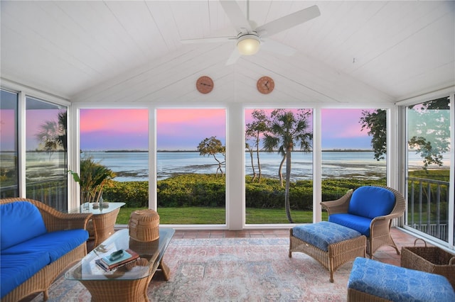 sunroom with a water view, vaulted ceiling, and expansive windows