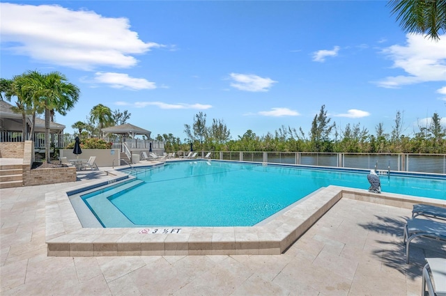 community pool featuring fence and a patio area