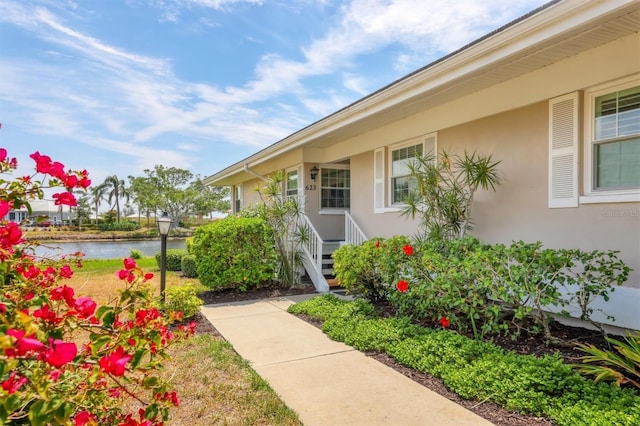 doorway to property featuring a water view and stucco siding