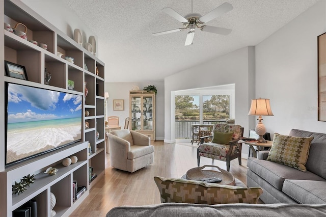 living area featuring a textured ceiling, light wood finished floors, and ceiling fan