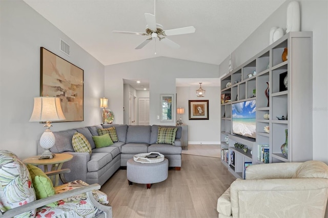 living area with ceiling fan, lofted ceiling, wood finished floors, and visible vents