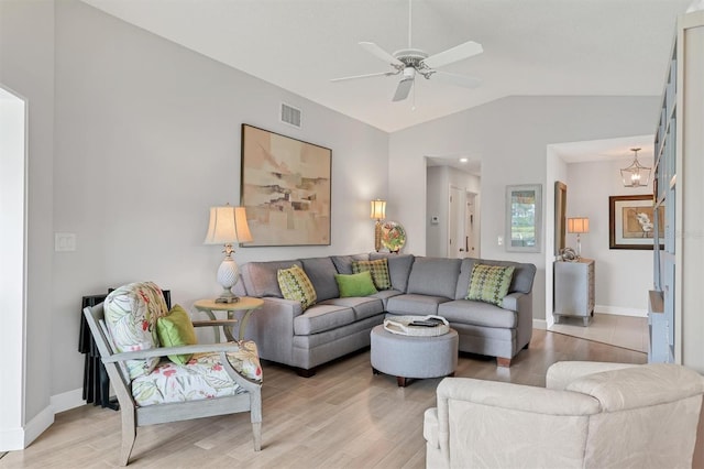 living room featuring lofted ceiling, light wood-style flooring, visible vents, and ceiling fan