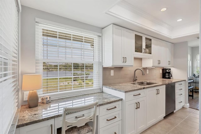 kitchen with a wealth of natural light, stainless steel dishwasher, a sink, and backsplash