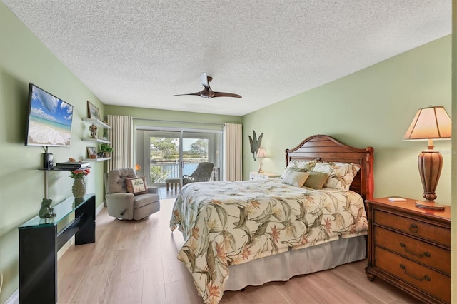 bedroom with wood finished floors, a textured ceiling, a ceiling fan, and access to outside
