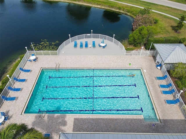 view of swimming pool with a water view and fence