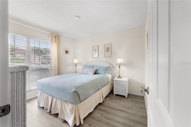4610 Runabout Way, Bradenton, FL 34203 - bedroom with a textured ceiling, light wood finished floors, and baseboards