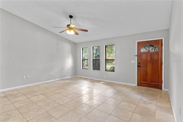 920 36th St W, Bradenton, FL 34205 - entryway featuring vaulted ceiling, ceiling fan, a textured ceiling, light tile patterned floors, and baseboards