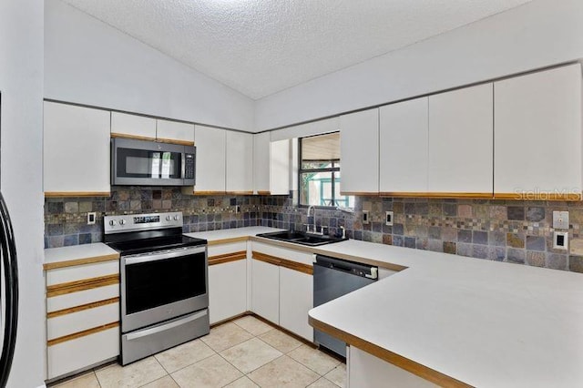 920 36th St W, Bradenton, FL 34205 - kitchen featuring stainless steel appliances, a sink, lofted ceiling, white cabinets, and a textured ceiling