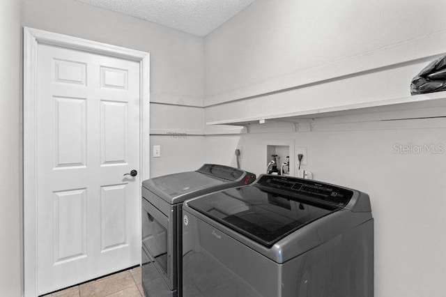 920 36th St W, Bradenton, FL 34205 - laundry area with washer and clothes dryer, light tile patterned floors, and a textured ceiling