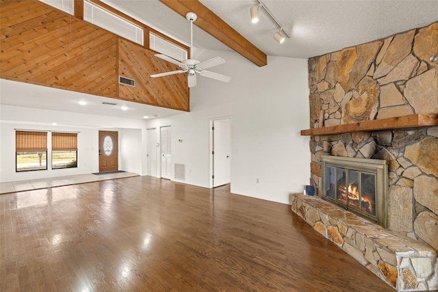 6547 Samoa Dr, Sarasota, FL 34241 - unfurnished living room featuring a stone fireplace, a towering ceiling, a ceiling fan, beam ceiling, and wood finished floors