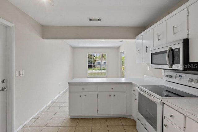 3505 27th Ave W, Bradenton, FL 34205 - kitchen featuring white electric range, stainless steel microwave, light countertops, a peninsula, and light tile patterned flooring