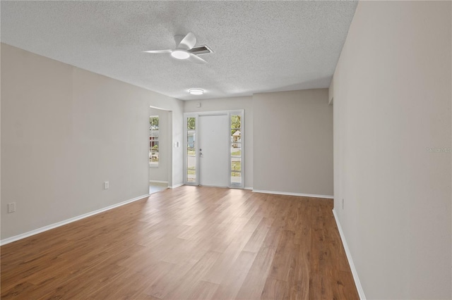 3505 27th Ave W, Bradenton, FL 34205 - unfurnished room featuring ceiling fan, light wood-style floors, baseboards, and a textured ceiling