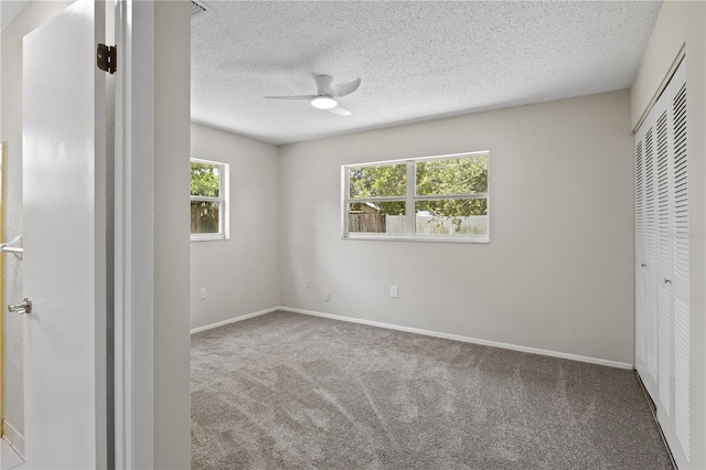 3505 27th Ave W, Bradenton, FL 34205 - unfurnished bedroom with carpet, a closet, multiple windows, a textured ceiling, and baseboards