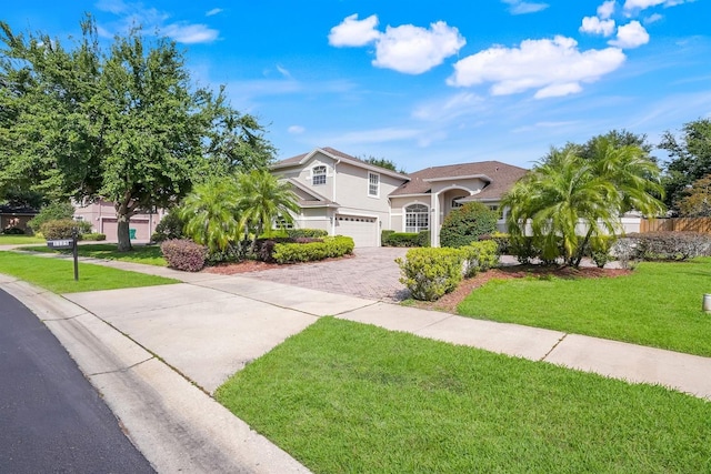 1125 English Garden Ln, Winter Garden, FL 34787 - mediterranean / spanish-style home with stucco siding, driveway, a front yard, and a garage