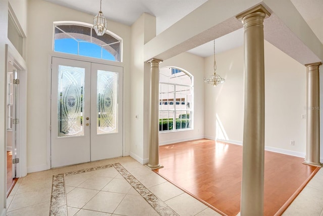 1125 English Garden Ln, Winter Garden, FL 34787 - entryway with a chandelier, a towering ceiling, ornate columns, and french doors