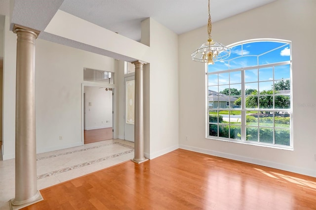 1125 English Garden Ln, Winter Garden, FL 34787 - unfurnished dining area with a chandelier, baseboards, and decorative columns