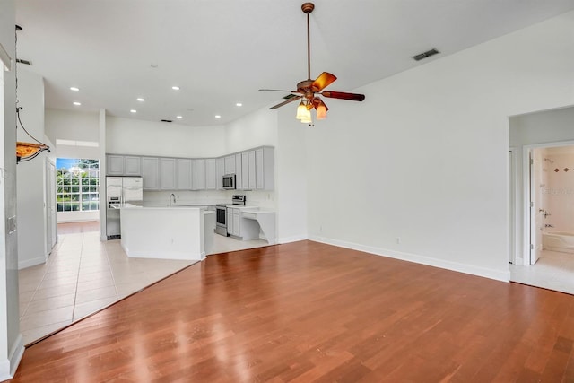 1125 English Garden Ln, Winter Garden, FL 34787 - unfurnished living room featuring a ceiling fan, a sink, a towering ceiling, visible vents, and recessed lighting