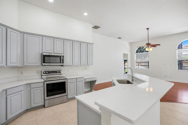 1125 English Garden Ln, Winter Garden, FL 34787 - kitchen with stainless steel appliances, a sink, visible vents, gray cabinets, and light tile patterned floors