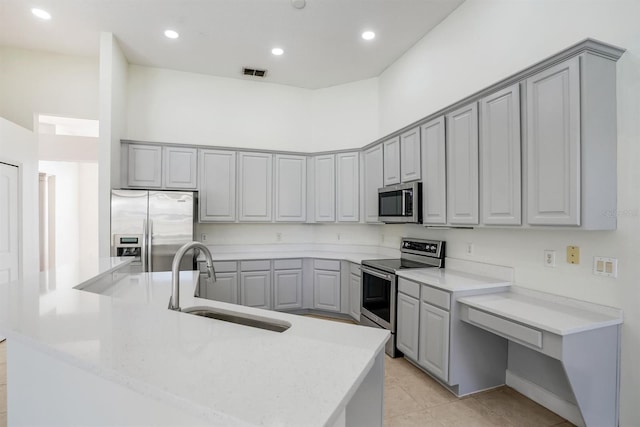 1125 English Garden Ln, Winter Garden, FL 34787 - kitchen with an island with sink, visible vents, gray cabinets, a sink, and appliances with stainless steel finishes