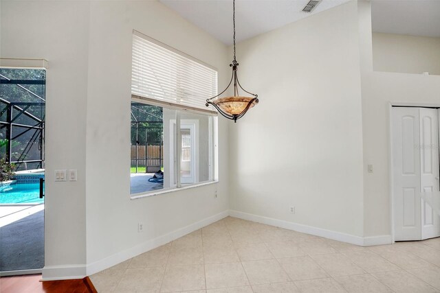 1125 English Garden Ln, Winter Garden, FL 34787 - unfurnished dining area with visible vents, a high ceiling, baseboards, and tile patterned flooring
