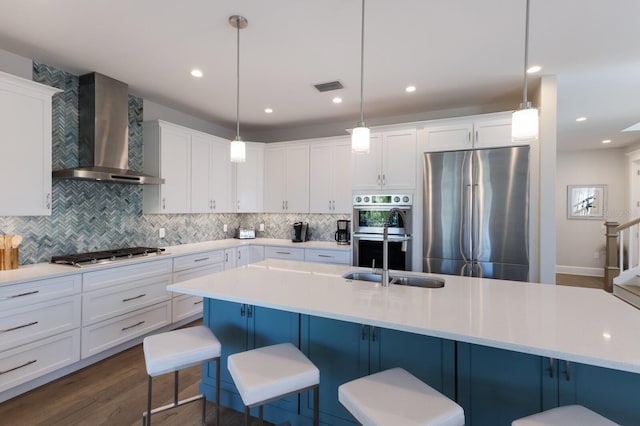 222 Willow Ave, Anna Maria, FL 34216 - kitchen featuring visible vents, decorative backsplash, wall chimney exhaust hood, a sink, and stainless steel appliances