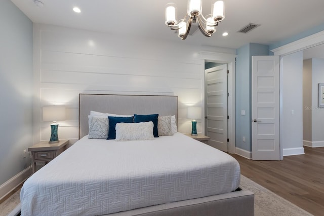 222 Willow Ave, Anna Maria, FL 34216 - bedroom with baseboards, wood finished floors, visible vents, and an inviting chandelier