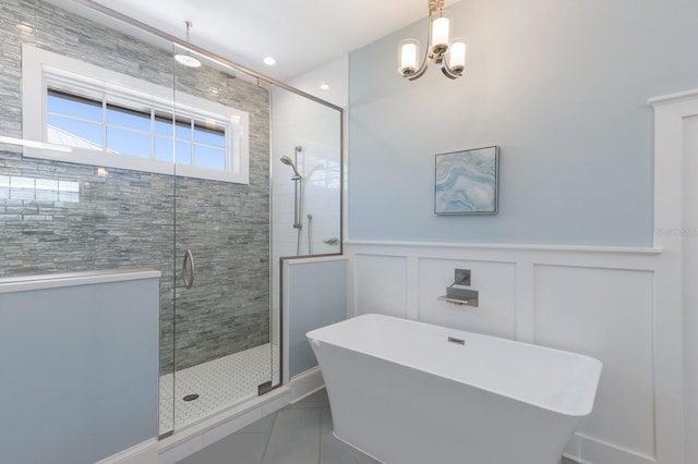 222 Willow Ave, Anna Maria, FL 34216 - bathroom with an inviting chandelier, a decorative wall, a wainscoted wall, a soaking tub, and a shower stall