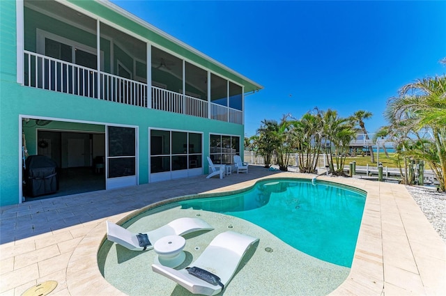 view of pool featuring a fenced in pool, a sunroom, and a patio area
