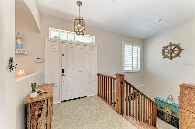 entrance foyer featuring a healthy amount of sunlight, tile patterned floors, and a chandelier