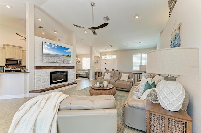living area featuring recessed lighting, light tile patterned floors, and ceiling fan with notable chandelier