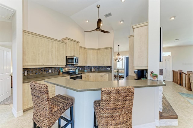 kitchen featuring light brown cabinets, stainless steel appliances, decorative backsplash, light tile patterned floors, and visible vents
