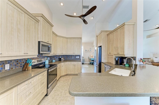 kitchen with appliances with stainless steel finishes, a sink, visible vents, and light brown cabinets