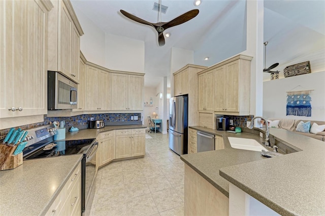 kitchen with a sink, light brown cabinetry, stainless steel appliances, and visible vents