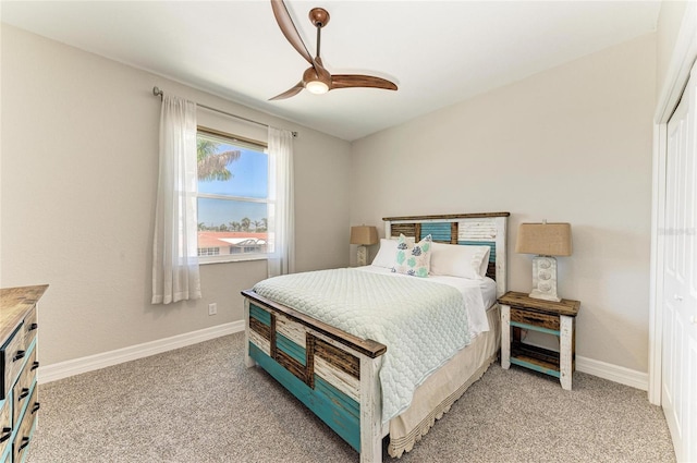 bedroom with light colored carpet, baseboards, and ceiling fan