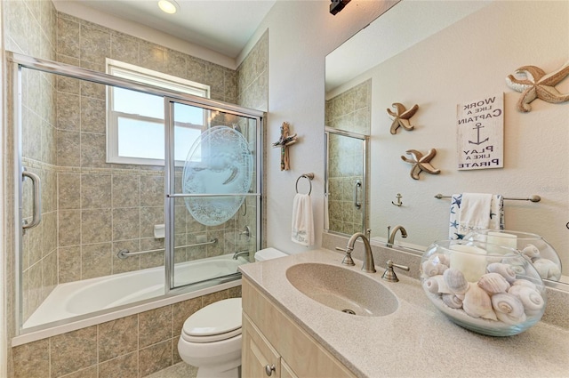 bathroom with vanity, tiled shower / bath, and toilet