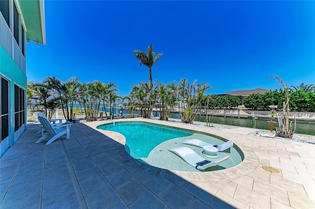 outdoor pool featuring a water view and a patio area