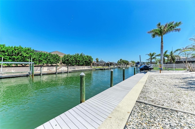 view of dock featuring fence and a water view