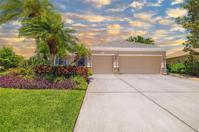 7804 Edmonston Cir, University Park, FL 34201 - view of front of house featuring a lawn, a garage, stucco siding, and driveway