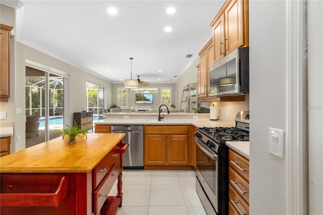 7804 Edmonston Cir, University Park, FL 34201 - kitchen with a peninsula, wooden counters, recessed lighting, a sink, and stainless steel appliances