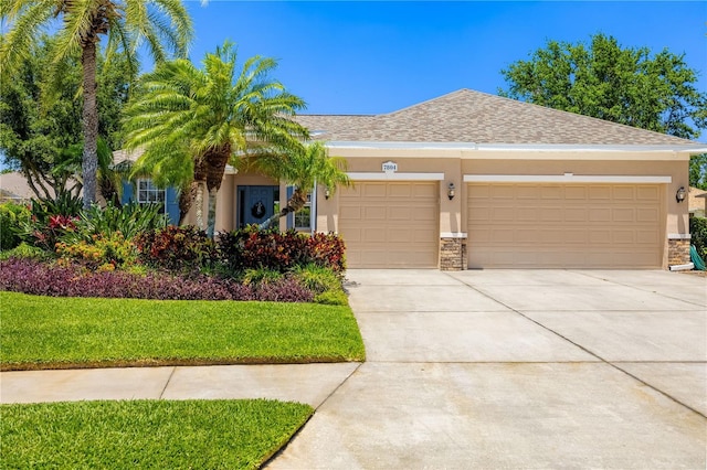 7804 Edmonston Cir, University Park, FL 34201 - view of front facade with a garage, stucco siding, stone siding, and concrete driveway