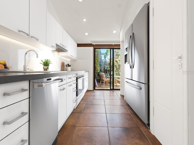 kitchen with stainless steel appliances, recessed lighting, white cabinetry, dark tile patterned floors, and dark countertops