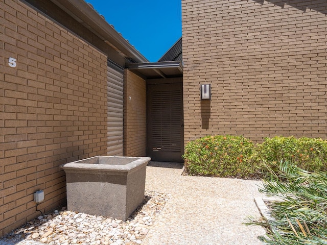 view of exterior entry featuring brick siding
