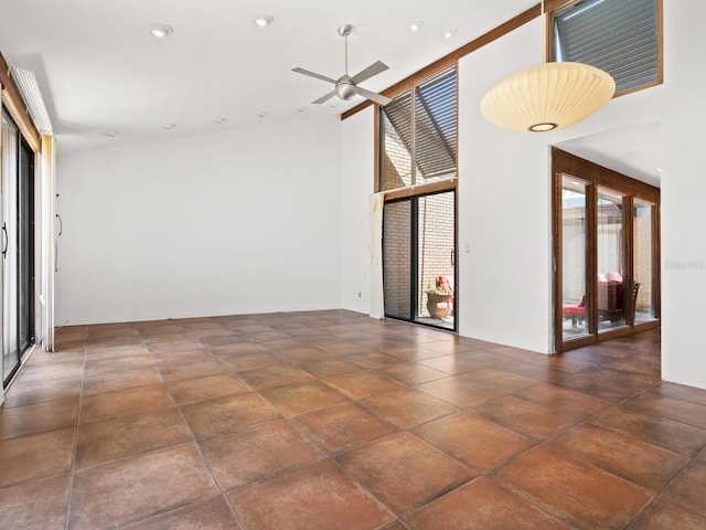 spare room featuring healthy amount of natural light, ceiling fan, a towering ceiling, and recessed lighting