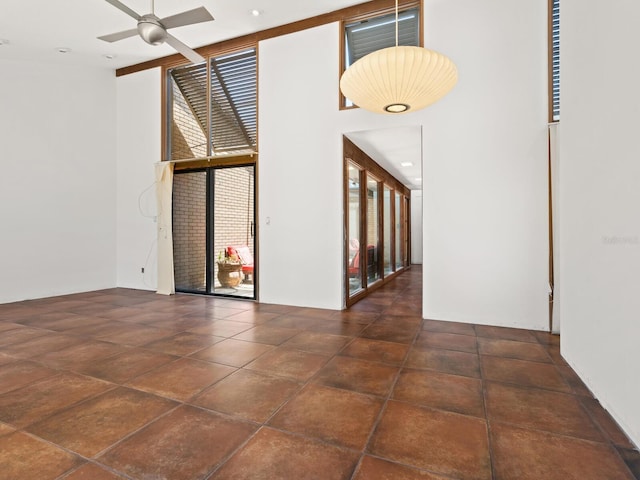 unfurnished room featuring ceiling fan and a towering ceiling