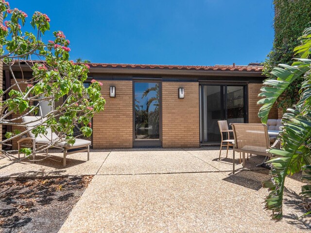 back of house with a patio area and brick siding