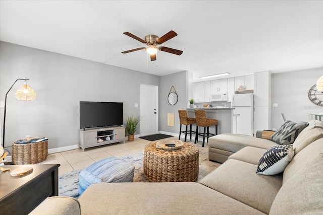 living room featuring light tile patterned floors, baseboards, and ceiling fan