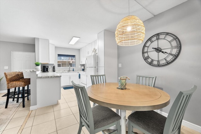 dining space with baseboards and light tile patterned floors