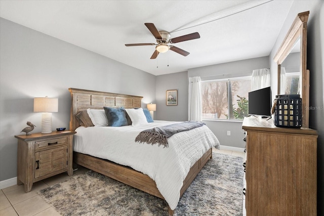 bedroom featuring baseboards, ceiling fan, and light tile patterned floors
