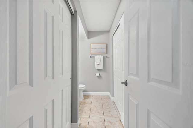 bathroom featuring baseboards and toilet