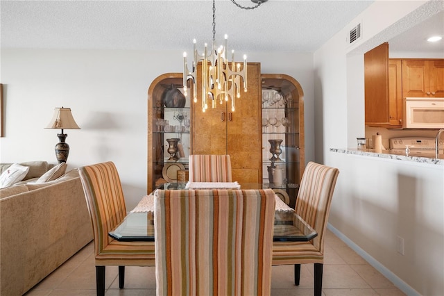 6460 Mourning Dove Dr Unit 102, Bradenton, FL 34210 - dining room with light tile patterned flooring, a chandelier, arched walkways, and a textured ceiling